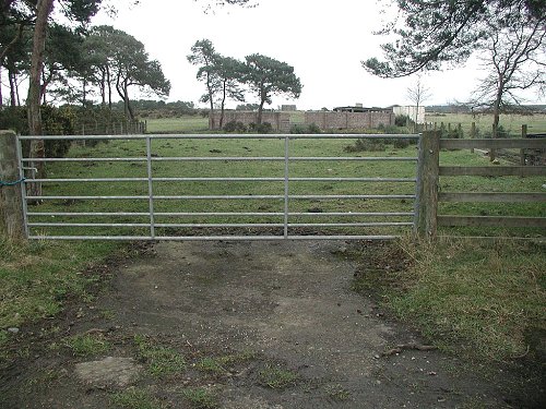 RAF Dallachy Today, the old main gate with the Control tower on the horizon.