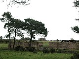 RAF Dallachy Today, the old main gate with the Control tower on the horizon.